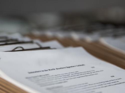 Image of stacked papers or patient charts from UnSplash