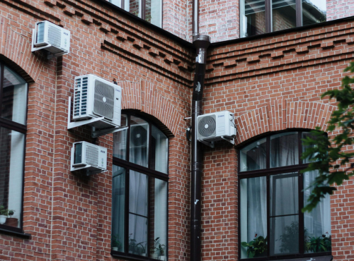Air Conditioners attached to exterior walls of housing