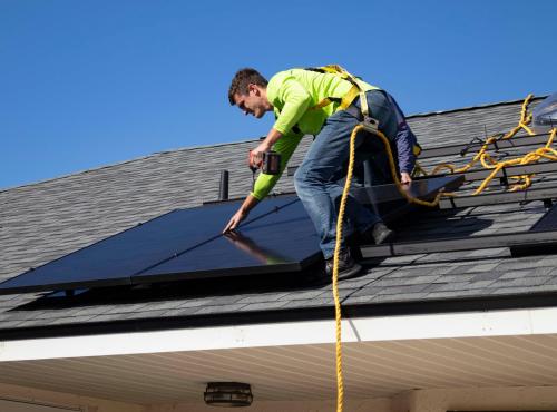 Man installing solar panel on roof