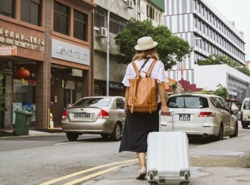 Woman pulling suitcase on the streets of a city.