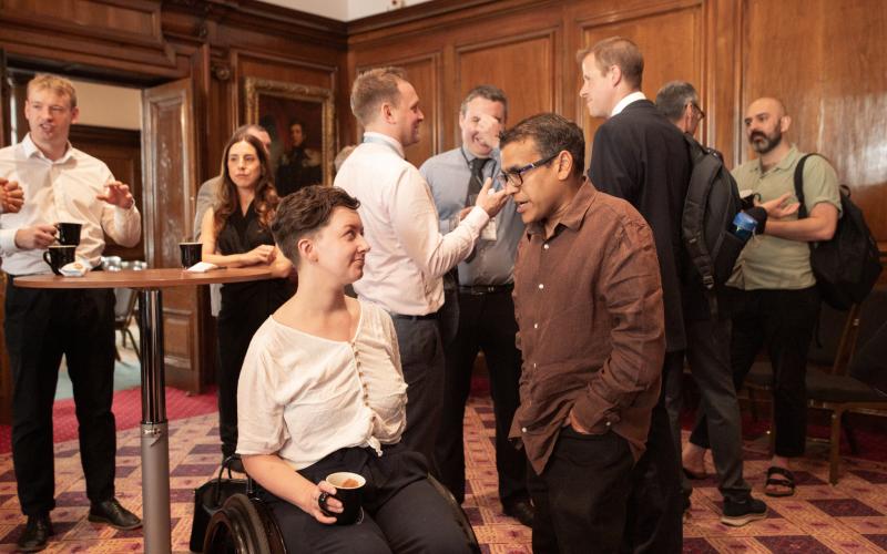 Attendees mingling, guest in wheelchair networking with another guest