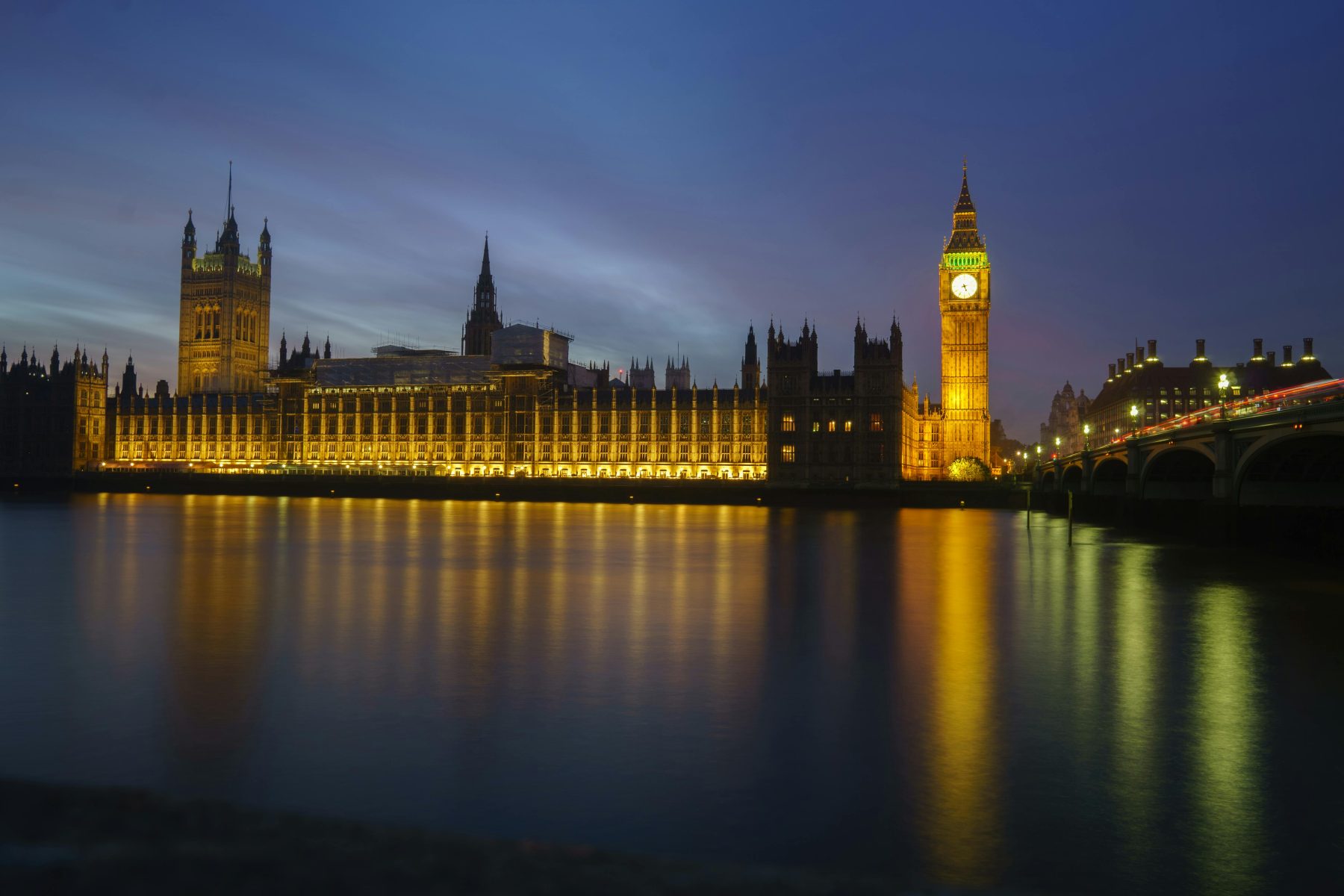 Westminster Palace across the Thames, in the dark. Building lit up with lights.